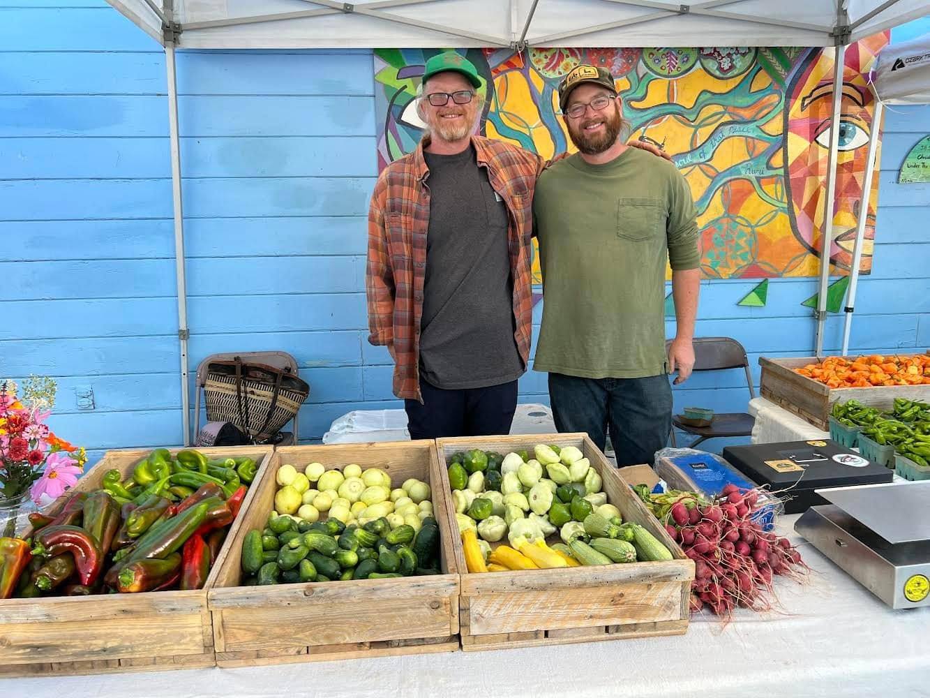Josh and Zach behind their farmers market table